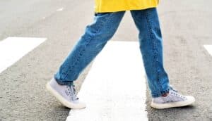 A person walks across a street in a crosswalk.