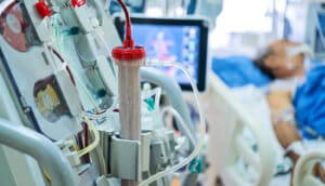 A person in the hospital with dialysis machinery next to their bed.