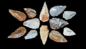 Spear and arrow points made of stone on a black background.