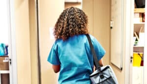 A nurse walks towards an exit door in a hospital office.
