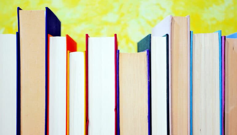 A row of textbooks on a shelf.