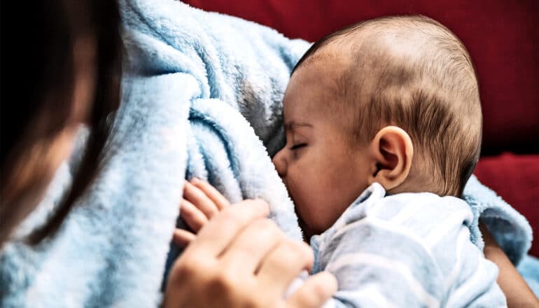 A mother breast feeds her baby.