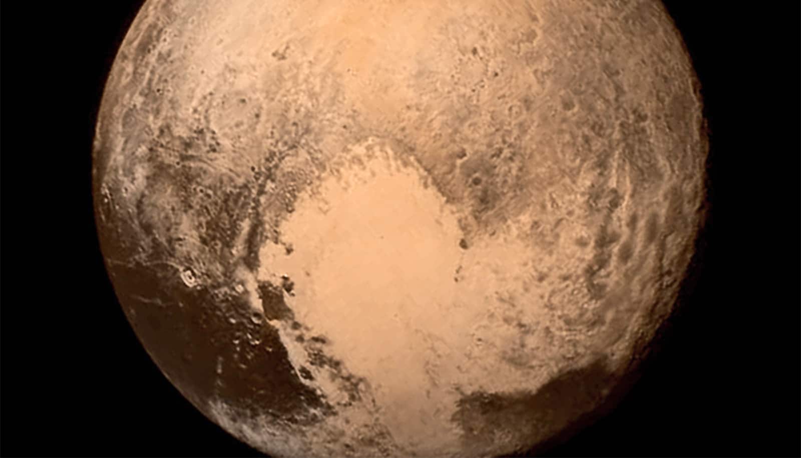 A shot of Pluto against a black background shows a brown surface.
