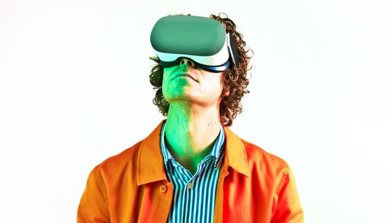 A man wears a virtual reality headset and looks upward.