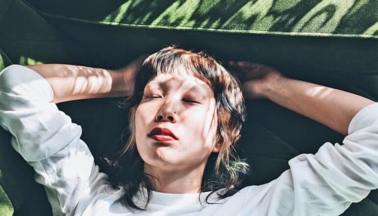 A young woman sleeps on a couch.