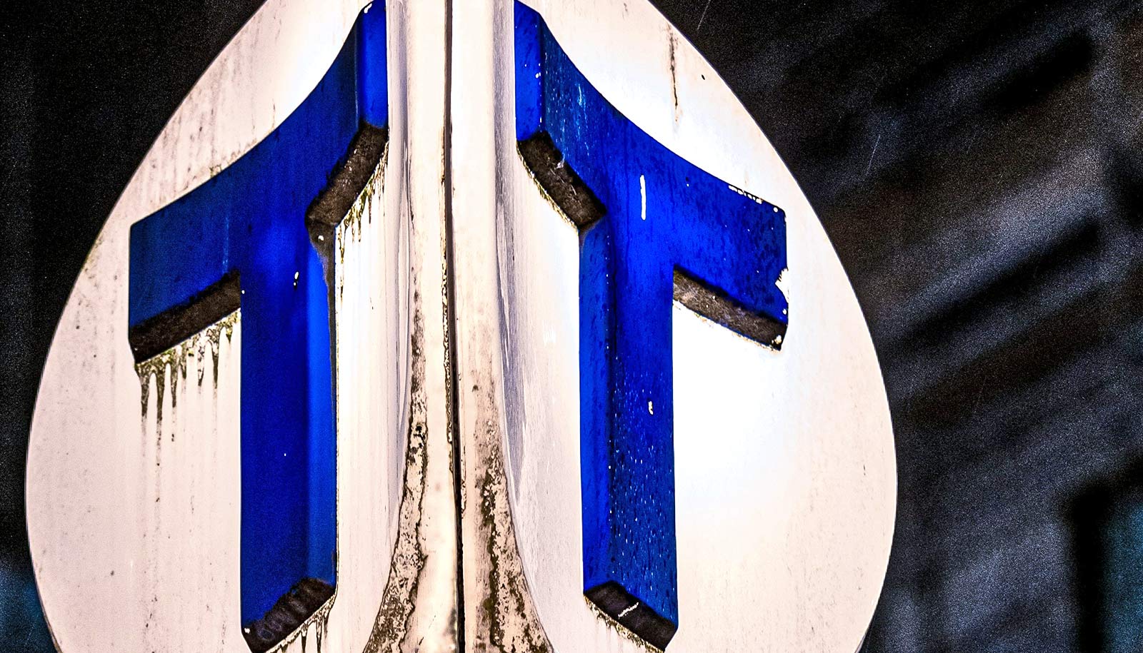 A road sign with two blue letter T's.