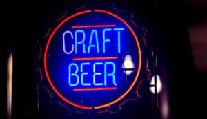 A blue and red neon sign reads "Craft Beer."