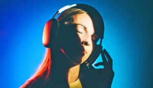 A woman listens to music while wearing large over-the-ear headphones.