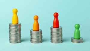 Four stacks of coins with small, differently colored game pieces standing on top of each.