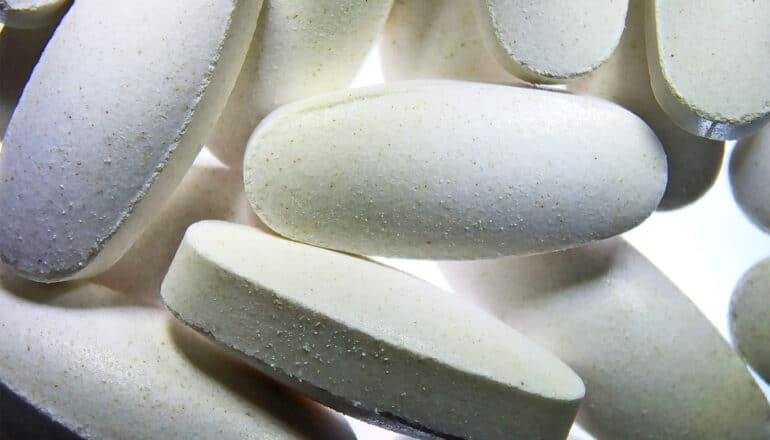 A close up of many white pills.