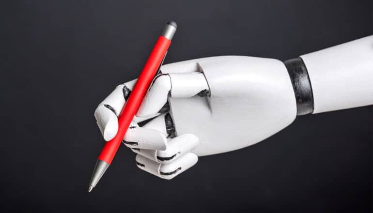 A robotic hand holds a pen against a black background.