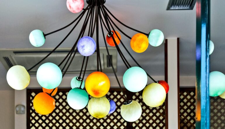A light fixture with several spheres of different colors that look like planets.