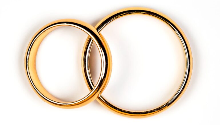 Two gold wedding rings on a white background.
