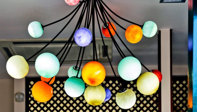A lamp with many colorful bulbs that look like planets.