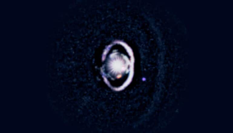 A view of a planet surrounded by a purple ring in the blackness of space.