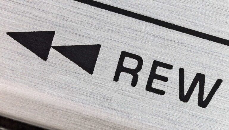 A close up of a rewind button on a tape or cd player.