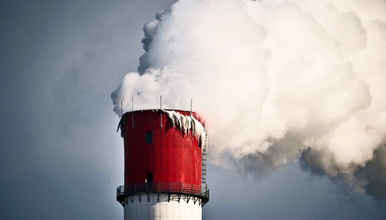 Smoke pours out of a power plant smoke stack.