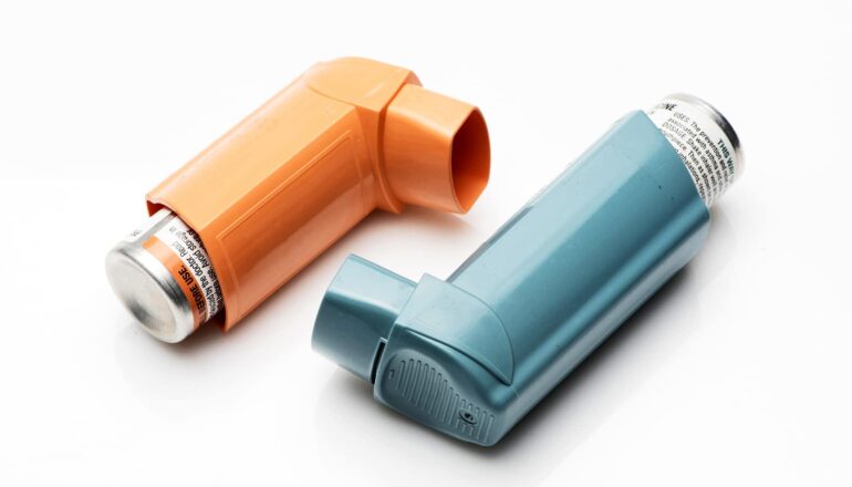 Two different colored inhalers on a white background.