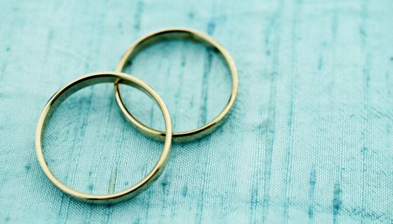 A pair of wedding rings on blue cloth.