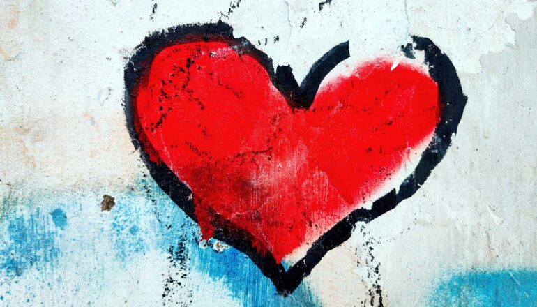 A painting of a heart on a white wall.