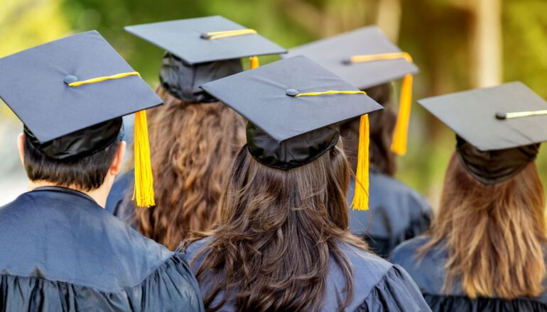 A group of graduating college students wearing mortarboards.