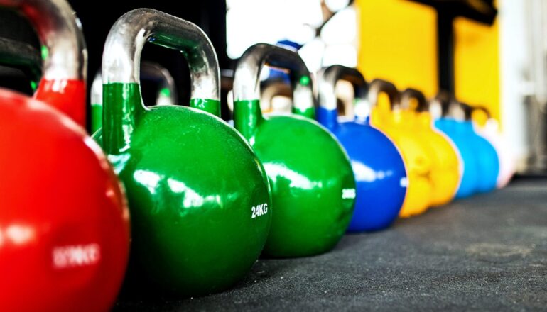A row of kettlebell weights in a gym.