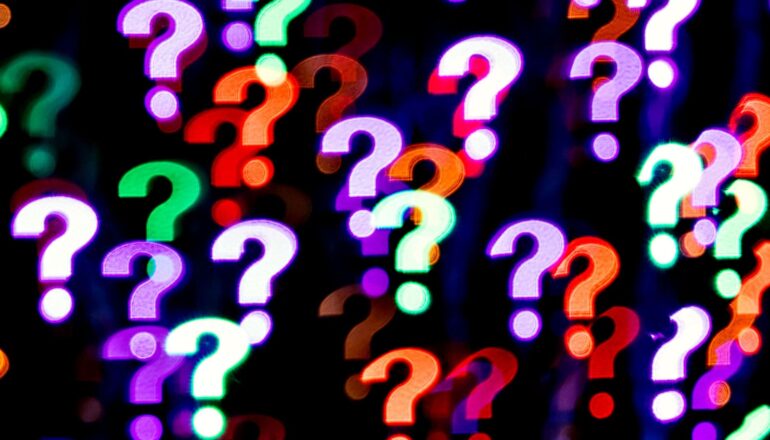 Many differently colored questions marks on a black background.