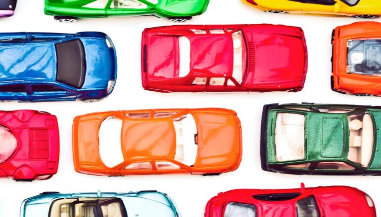 Colorful toy cars on a white surface.