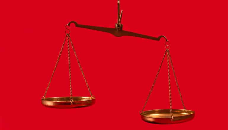 Uneven scales on a red background.