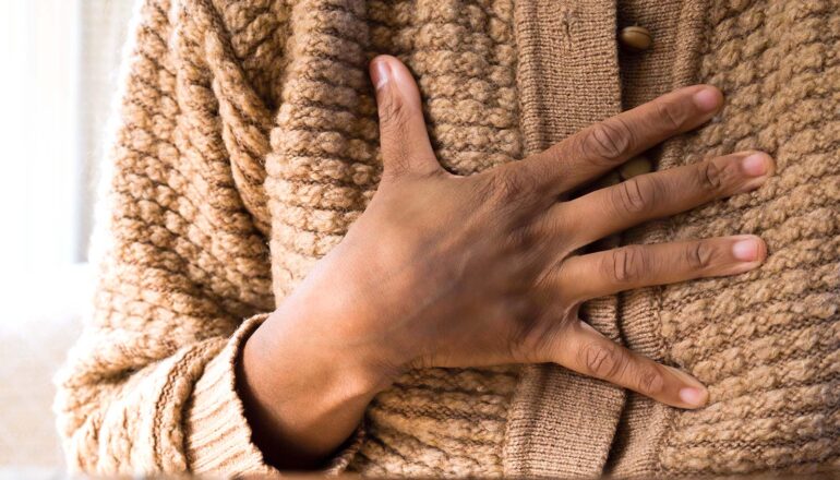 A woman clutches her chest.