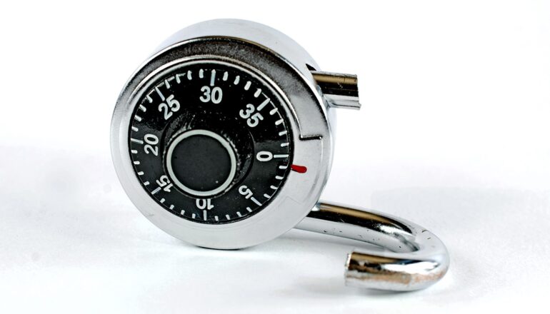 A broken combination lock on a white background.