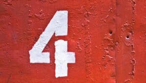 A number four painted on a red wall in white.