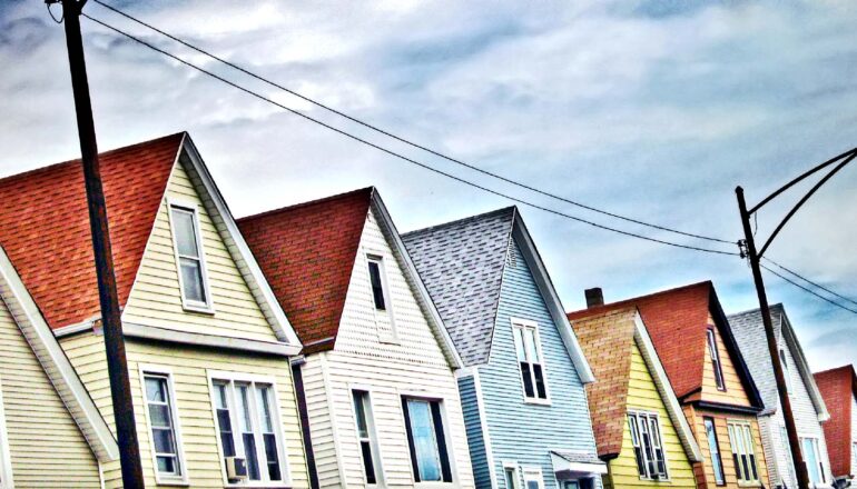 A row of houses with a cloudy sky above them.