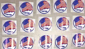 Rows of "I voted" stickers with American flags on them.