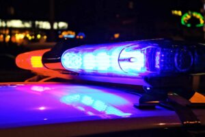 Police car lights flash blue and red at night.