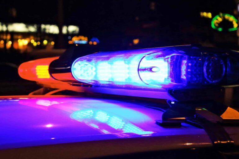 Police car lights flash blue and red at night.